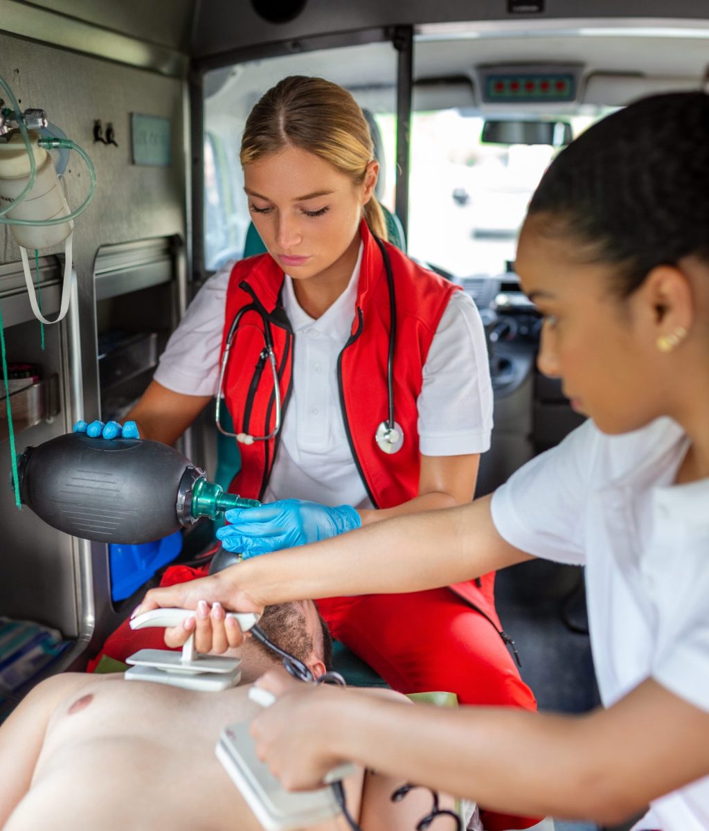 Paramedic using defibrillator (AED) in conducting a basic cardiopulmonary resuscitation. Emergency Care Assistant Putting Silicone Manual Resuscitators in an Ambulance.